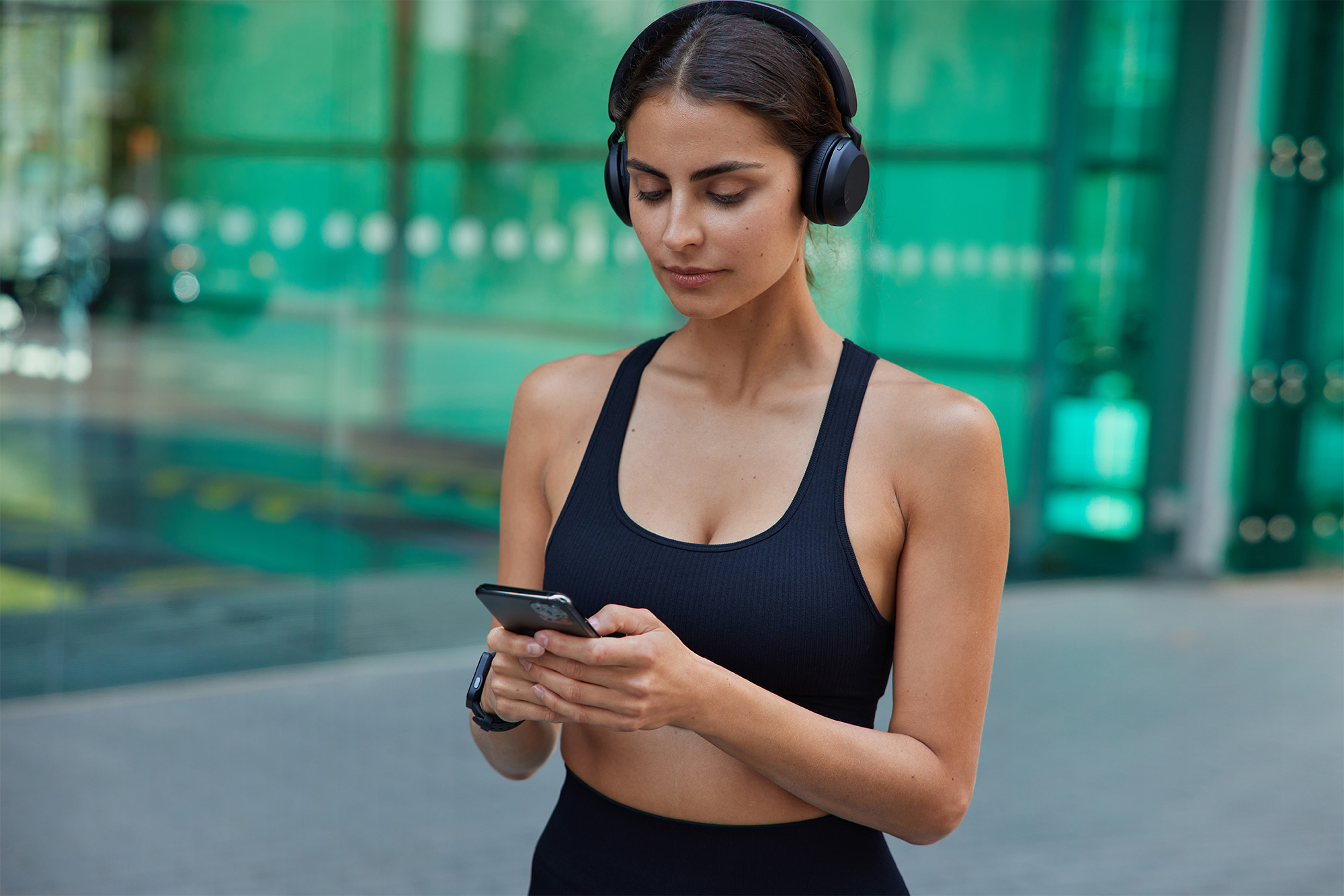 Sportieve vrouw die op telefoon op zoek is naar nieuwe sportschoenen